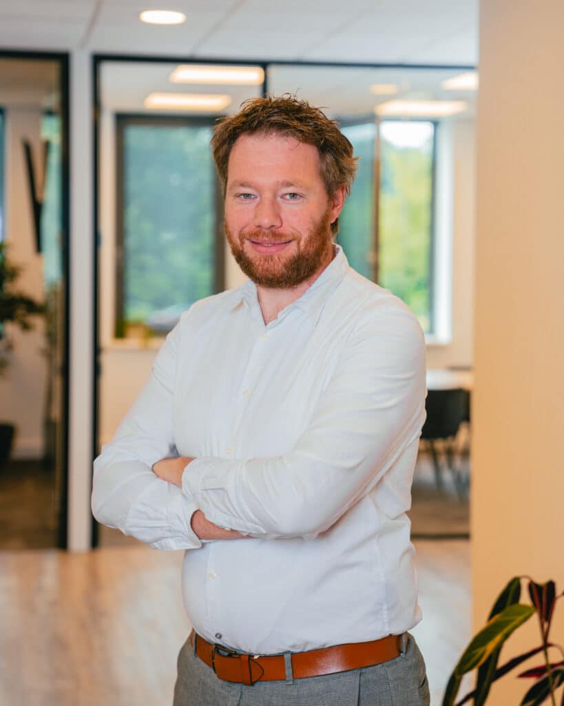 Man in white blouse in office smiling at the camera